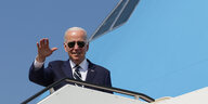 Joe Biden steht vor einem Flugzeug und winkt