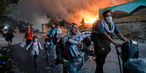 Menschen aus dem FLüchtlingslager Moria flüchten vor den Flammen