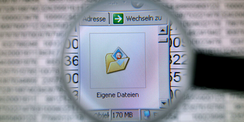 Hinter einer Lupe ist der Ordner «Eigene Dateien» auf einem Computerbildschirm zu sehen