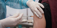 Ein junger Mann wird mit einer Booster-Dosis eines Corona-Impfstoffs geimpft