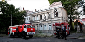 Ein Feuerwehrauto steht vor einem älteren Gebäude