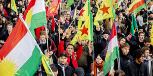 Menschen mit kurdischen Fahnen demonstrieren in Berlin gegen den türkischen Angriffskrieg