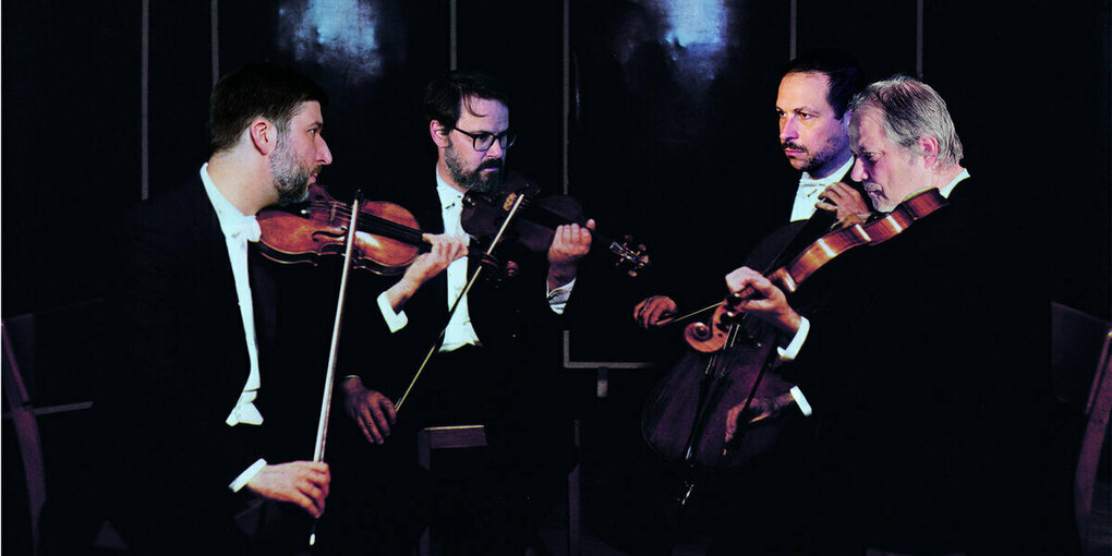 Das Baldrian Quartett mit Instrumenten vor dunklem Hintergrund