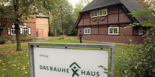 Ein Fachwerk-Haus, davor steht ein Schild mit der Aufschrift "Rauhes Haus".