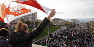 Eine Frau schwingt eine belarussische Fahne