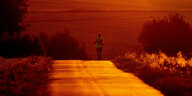 Ein Mann joggt die Straße entlang im Sonnenaufgang