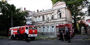 Feuerwehrwagen vor einem älteren Wohnhaus