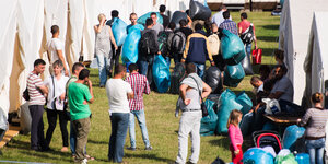 Flüchtlinge vor Zeltunterkünften