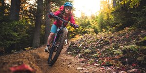 Eine Mountenbikerin mit Helm im Wald