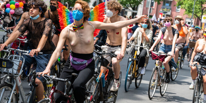 Viele Fahrradfahrer*innen mit nachktem Oberkörper