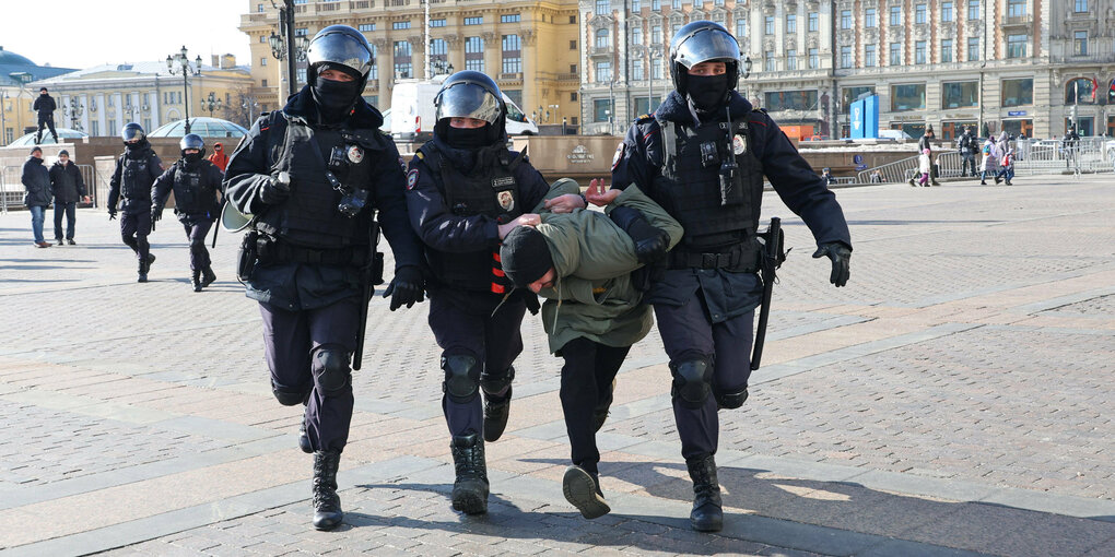 Polizisten zerren einen Mann weg