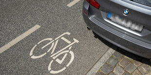 Ein Auto ist auf einem Fahrradweg geparkt