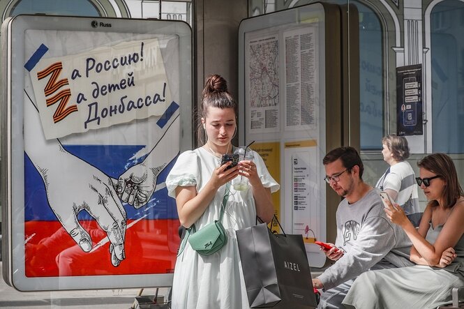 Menschen an einer Bushaltestelle in Moskau