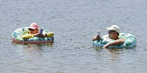 Zwei Personen mit Schimmreifen im Wasser