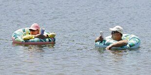 Zwei Personen mit Schimmreifen im Wasser