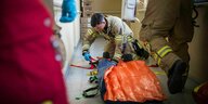 ettungssanitäter Felix Schapke bereitet eine Vakuummatratze zum Transport einer verletzten Frau vor