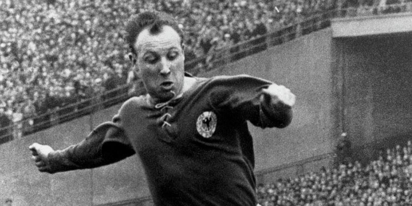 Eine schwarz-weiß-Aufnahme von Uwe Seeler als nationalspieler am Ball