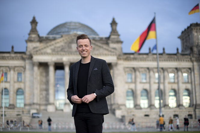 Ein Mann steht vor dem Reichstag