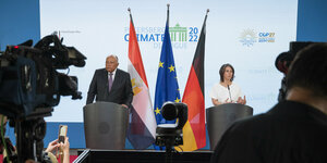 Ägyptens Außenminister Schukri und Bundesaußenministerin Baerbock an Rednerpulten, im Hintergrund Flaggen und die Aufschrift "Petersberg Climate Dialogue 2022".