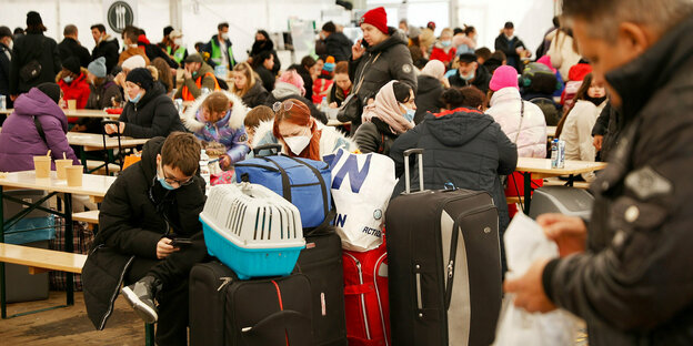 Flüchtlinge warten in einer Halle Flüchtlinge warten in einer Halle