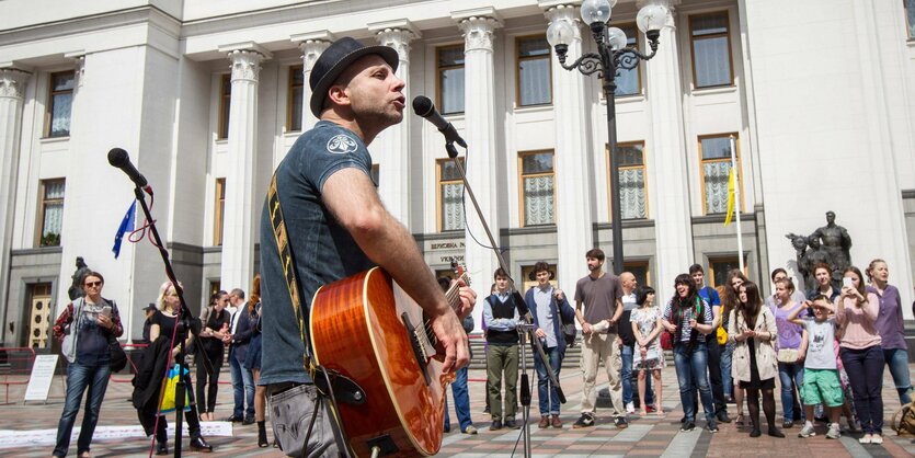 Vadim Krasnookiy singt auf einem Platz vor einigen Zuschauern