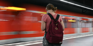 Eine Frau wartet im Hauptbahnhof auf die Einfahrt einer S-Bahn