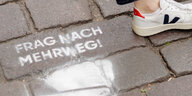 Stencil-Graffiti auf Straße "Frag nach Mehrweg!"