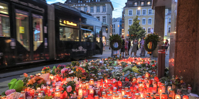 Meer von Blumen und Trauerlichtern am Abend auf einem Platz