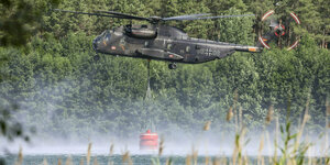 Bundeswehrhubschrauber holt Löschwasser aus einen Teich