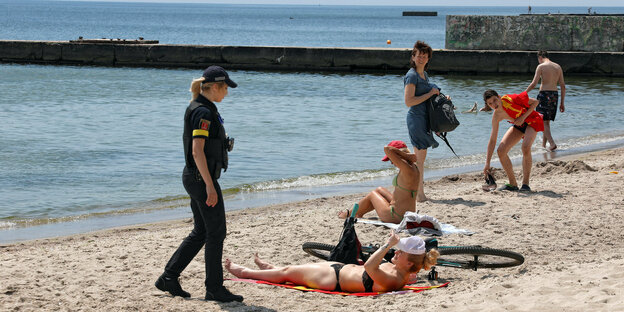 Eine Polizistin spricht mit Strandbesuchern