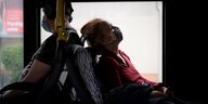 Zwei Menschen sitzen im Bus und tragen Masken