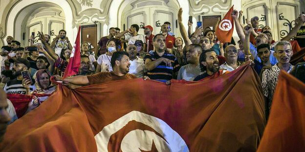 Eine feiernde Menge hinter der tunesischen Flagge