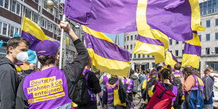 Menschen in Westen und mit Fahnen der Kampagne DW Enteignen