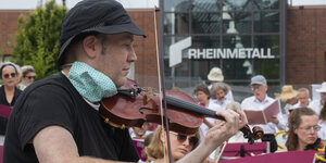 Ein Mann spielt Geige vor Publikum, ein Foto vom Lebenslaute-Konzert im August 2020 vor dem Rüstungskonzern Rheinmetall