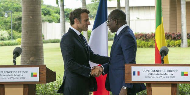 Die Präsidenten Macron und Talon schauen sich beim Handshake in die Augen.