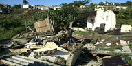 Ein Mann steht inmitten zerstörter Häuser