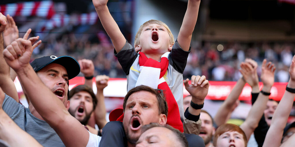 Singende Fans auf der Tribüne eines Stadions