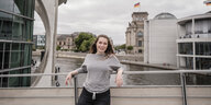 Eine junge Frau steht vor dem Reichstag