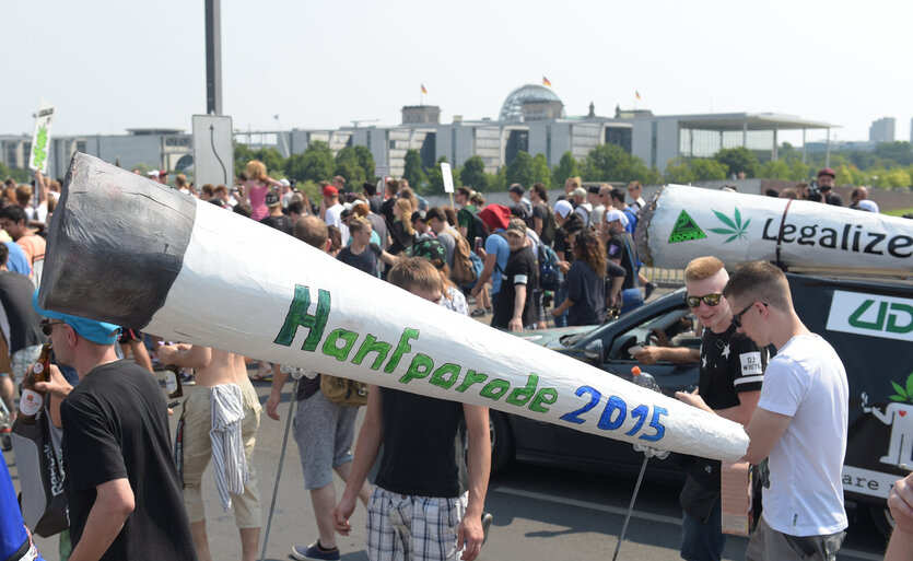 Demonstranten halten überdimensionierte Joint-Attrappen