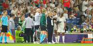 Englands Trainerin und ihr Betreuerinnenstab am Spielfeldrand schauen auf ein Klemmbrett