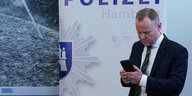 Hamburgs Innensenator Andy Grote (SPD) schaut auf ein Smartphone