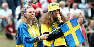 Zwei schwedische Anhängerinnen mit schwedischer Fahne
