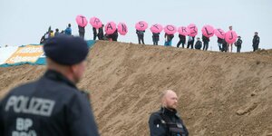 Klimaaktivisten haben einen Hügel auf dem Baufeld des Logistikers DHL am Flughafen Leipzig-Halle besetzt und halten mittels Regenschirmen den Schriftzug «Transform LEJ».