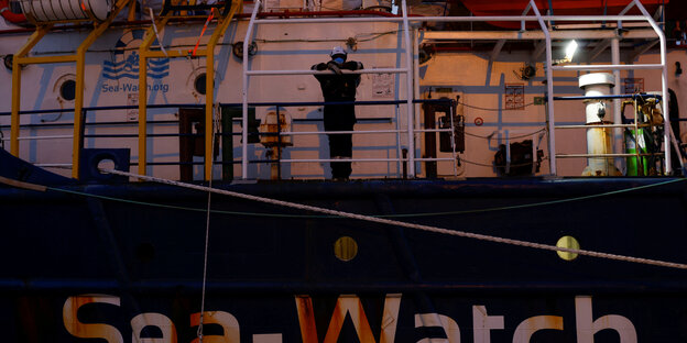 Ein Crew-Mitglied blickt von der Reling der Sea-Watch 3 in die Kamera.