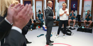 Kanzler Scholz in der Kabine des deutschen Fußball-Teams der Frauen, Umstehende applaudieren