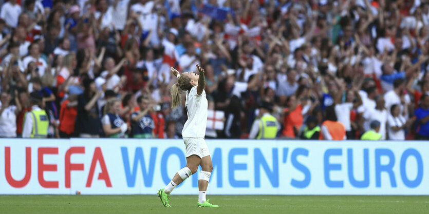 Englands Fußballerin Rachel Daly steht mit ausgebreiteten Armen auf dem Platz und blickt nach oben.