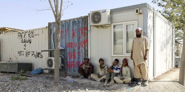 Afghanische Arbeiter vor den Resten des Bundeswehrstandorts in Kundus