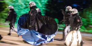 Polizisten tragen Zelte weg