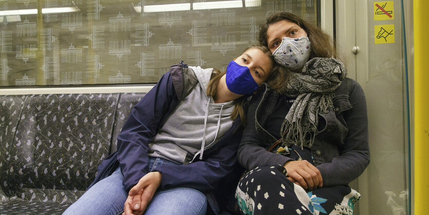 Zwei Personen mit Schutzmaske in der U-Bahn