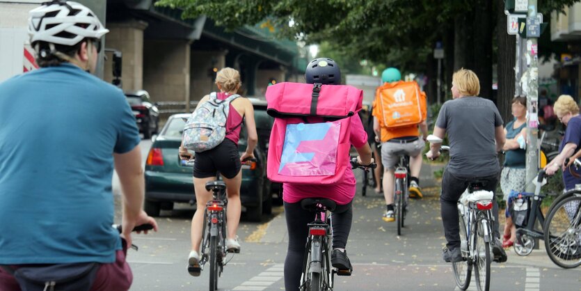 Kurierfahrer*innen von Flink und Lieferando auf einer Berliner Straße.